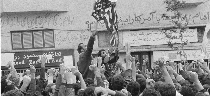 An Iranian protestor sets fire to a U.S. flag while other demonstrators clench their fists during an anti-American protest in Tehran, Nov. 5, 1979.