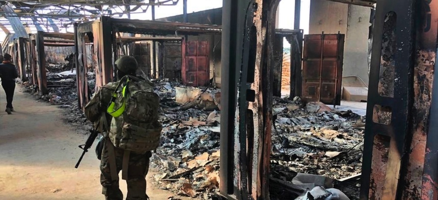 U.S. Soldiers walk past a site of Iranian bombing at Ain al-Asad air base, in Anbar, Iraq, Monday, Jan. 13, 2020