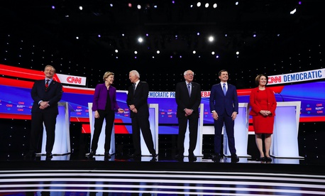Democratic presidential candidates stand on stage, Tuesday, Jan. 14, 2020, before a Democratic presidential primary debate hosted by CNN and the Des Moines Register in Des Moines, Iowa.