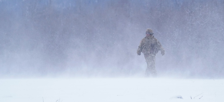 A soldier assigned to the 25th Infantry Division, U.S. Army Alaska, in a helicopter’s rotor wash while training with aviators from the Alaska Army National Guard at Neibhur Drop Zone, Nov. 26, 2019.