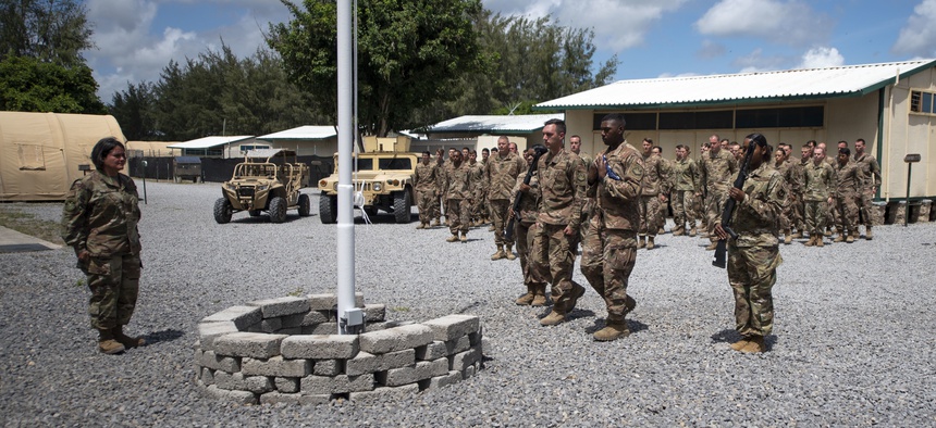 In this photo taken Aug. 26, 2019 and released by the U.S. Air Force, airmen from the 475th Expeditionary Air Base Squadron conduct a flag-raising ceremony, signifying the change from tactical to enduring operations, at Camp Simba, Manda Bay, Kenya.