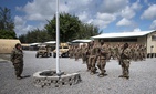 In this photo taken Aug. 26, 2019 and released by the U.S. Air Force, airmen from the 475th Expeditionary Air Base Squadron conduct a flag-raising ceremony, signifying the change from tactical to enduring operations, at Camp Simba, Manda Bay, Kenya. In this photo taken Aug. 26, 2019 and released by the U.S. Air Force, airmen from the 475th Expeditionary Air Base Squadron conduct a flag-raising ceremony, signifying the change from tactical to enduring operations, at Camp Simba, Manda Bay, Kenya.