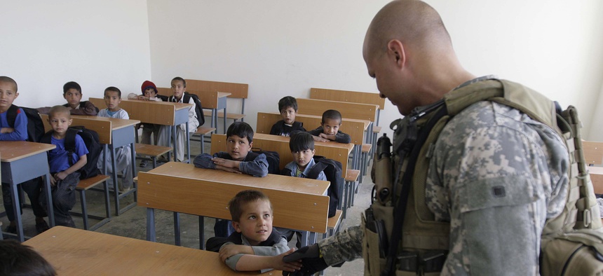 A US soldier of Combined Joint Special Operations Task Force Afghanistan shakes hand with an Afghan boy during the opening of a school in Bagram, north of Kabul, Afghanistan, Monday, March 24, 2008.