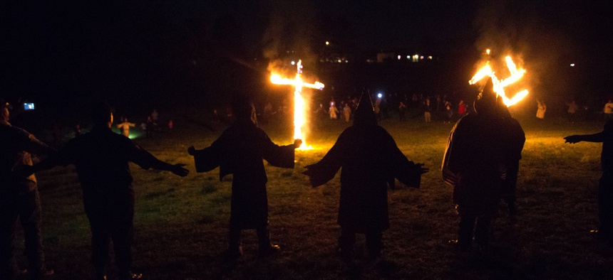 In this Saturday, April 23, 2016 photo, members of the Ku Klux Klan participate in cross and swastika burnings after a "white pride" rally in rural Paulding County near Cedar Town, Ga.