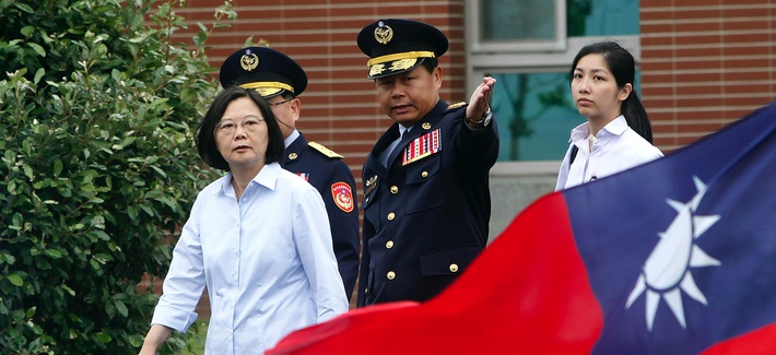 Taiwan's President Tsai Ing-wen, left, walks past a Taiwan national flag during an offshore anti-terrorism drill outside the Taipei harbor in New Taipei City, Taiwan, Saturday, May 4, 2019.