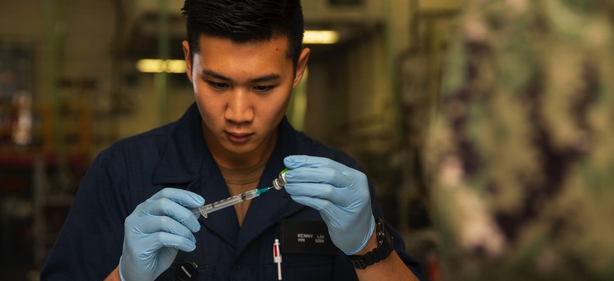 Navy Seaman Kenny Liu prepares a needle with a flu vaccination aboard the USS Gerald R. Ford in Newport News, Va., Oct. 22, 2019. The ship’s crew received flu vaccines.