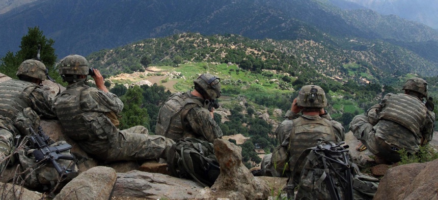 Soldiers from 2nd Battalion, 503rd Infantry Regiment, provide security during Operation Destined Strike while Soldiers below search a village in the Chowkay Valley in Kunar Province, Afghanistan.