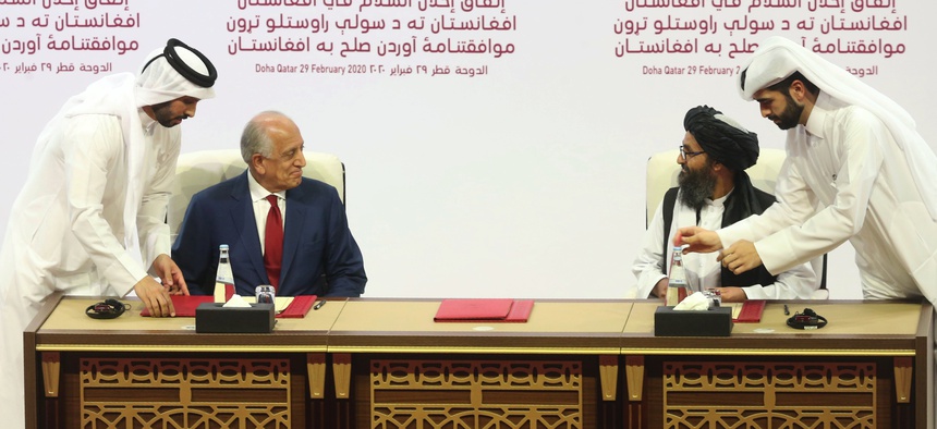 U.S. peace envoy Zalmay Khalilzad, left, and Mullah Abdul Ghani Baradar, the Taliban group's top political leader sign a peace agreement between Taliban and U.S. officials in Doha, Qatar, Saturday, Feb. 29, 2020.
