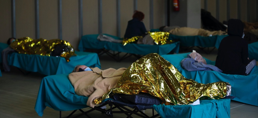 Patients lie on beds at one of the emergency structures that were set up to ease procedures at the Brescia hospital, northern Italy, Thursday, March 12, 2020.