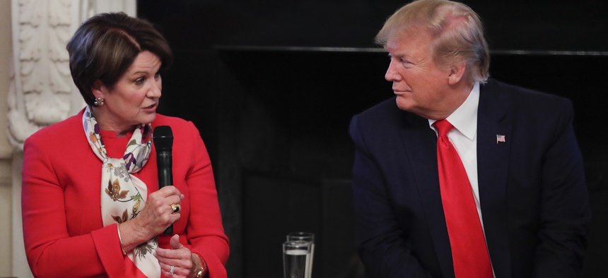 President Donald Trump looks to Marillyn Hewson, Chairman, President and CEO, Lockheed Martin as she speaks during a "Pledge to America's Workers" ceremony in the State Dining Room of the White House in Washington, Thursday, July 25, 2019.
