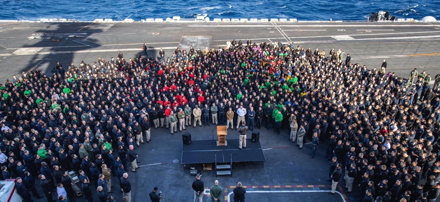In this Dec. 15, 2019, photo, Capt. Brett Crozier, commanding officer of the aircraft carrier USS Theodore Roosevelt (CVN 71), addresses the crew during an all hands call on the ship's flight deck while training in the eastern Pacific Ocean.