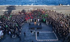 In this Dec. 15, 2019, photo, Capt. Brett Crozier, commanding officer of the aircraft carrier USS Theodore Roosevelt (CVN 71), addresses the crew during an all hands call on the ship's flight deck while training in the eastern Pacific Ocean. 