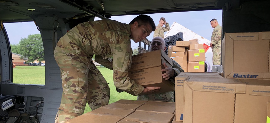 exas Army National Guard Soldiers load a UH-60 Black Hawk at Camp Mabry on April 8, 2020 with personal protective equipment for distribution in La Marque, Texas.