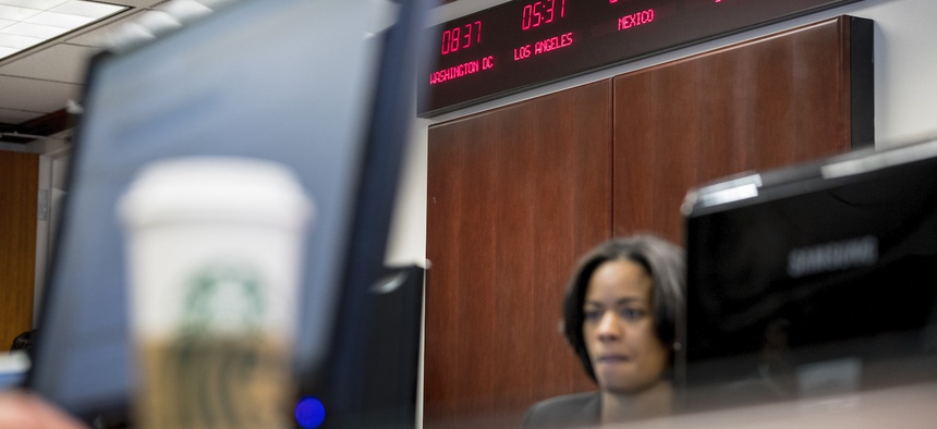 Digital clocks from different time zones around the world are displayed above Drug Enforcement Administration agents and intelligence analysts gathering information from field operations across the country at their command center. March 11, 2020