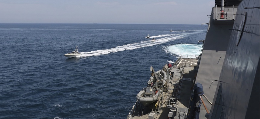 In this Wednesday, April 15, 2020, photo made available by U.S. Navy, Iranian Revolutionary Guard vessels sail close to U.S. military ships in the Persian Gulf near Kuwait.