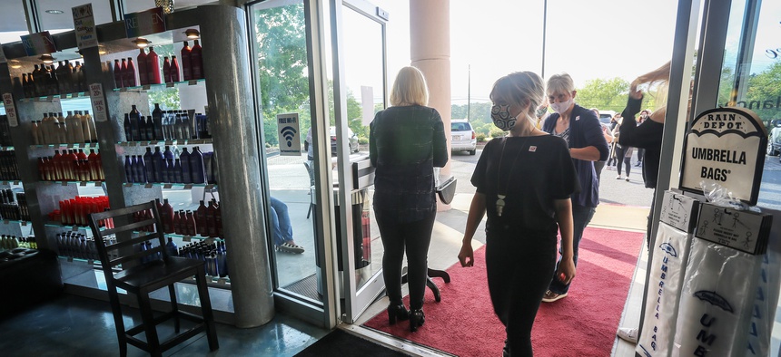 Employees and customers walk in to Three-13 Salon, Spa & Boutique on Friday, April 24, 2020, in Marietta, Ga.
