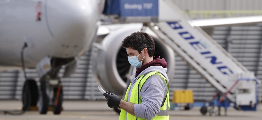 A worker walks past a Boeing 737 MAX jet at a Boeing airplane manufacturing plant Wednesday, April 29, 2020, in Renton, Wash.