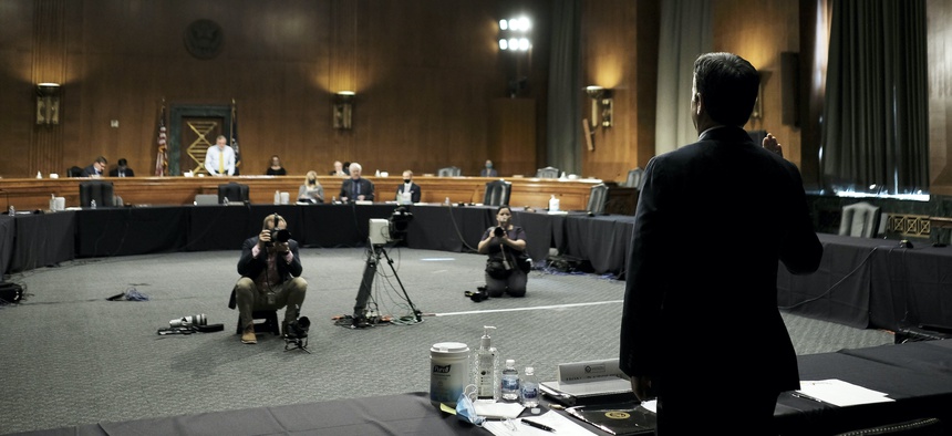 Rep. John Ratcliffe, R-Texas, right, is sworn in by Senate Intelligence Committee Chairman Sen. Richard Burr, R-N.C., standing left, before a Senate Intelligence Committee nomination hearing on Capitol Hill in Washington, Tuesday, May. 5, 2020.