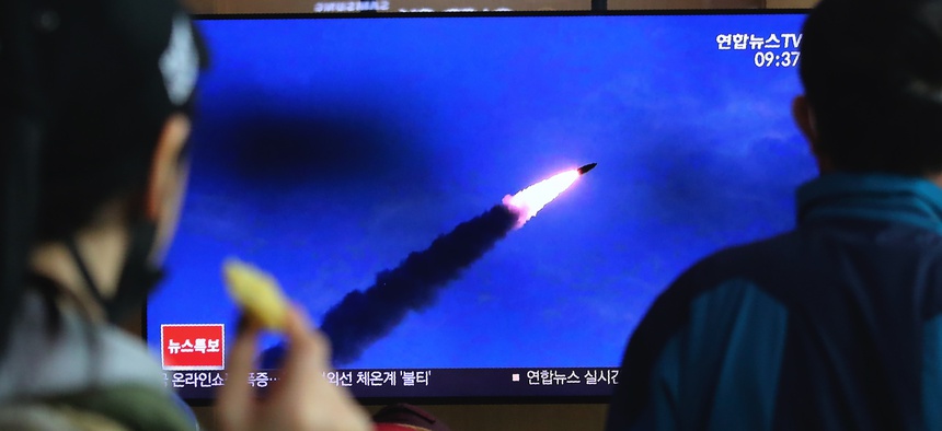 People watches a televsion screen showing a file image of North Korea's missile launch during a news program at the Seoul Railway Station in Seoul, South Korea, Saturday, March 21, 2020.