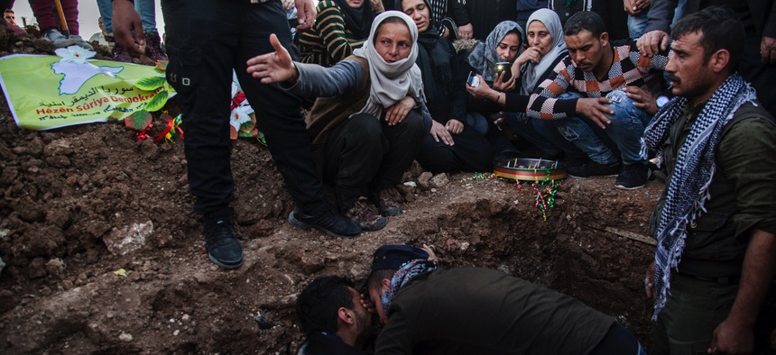 In this March 10, 2010, file, photo, people attend the funeral of a Syrian Democratic Forces fighter who was killed in a battle with remnants of the Islamic State group in eastern Syria