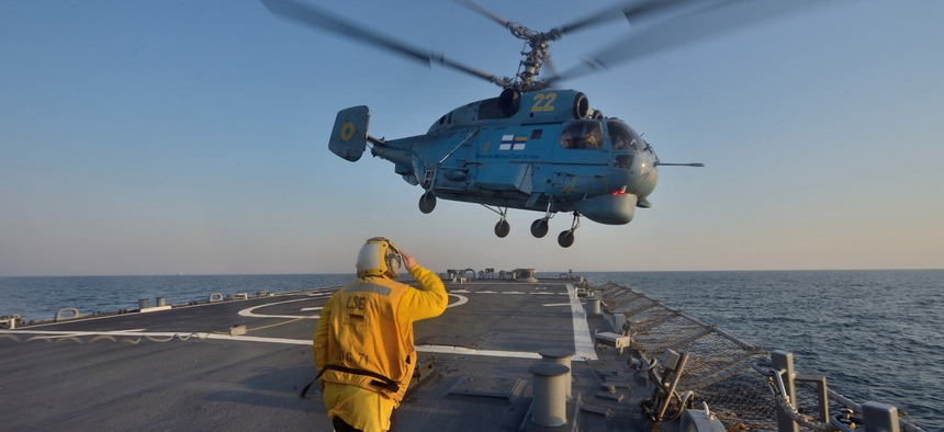 Boatswain’s Mate 3rd Class Jennifer Sahley salutes as a Ukrainian navy Ka-27 Helix helicopter takes off from the Arleigh Burke-class guided-missile destroyer USS Ross (DDG 71) during exercise Sea Breeze 2014 in the Black Sea.