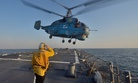 Boatswain’s Mate 3rd Class Jennifer Sahley salutes as a Ukrainian navy Ka-27 Helix helicopter takes off from the Arleigh Burke-class guided-missile destroyer USS Ross (DDG 71) during exercise Sea Breeze 2014 in the Black Sea.