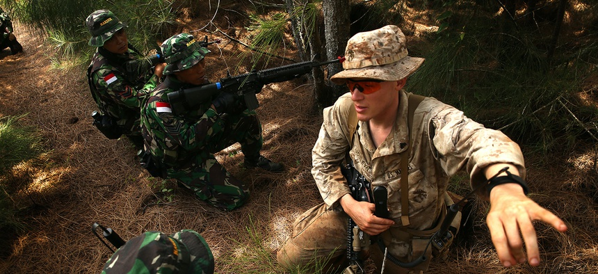 U.S. Marine Cpl. Joseph Josleyn talks with troops of Indonesia's Korps Marinir during Rim of the Pacific (RIMPAC) Exercise 2014.