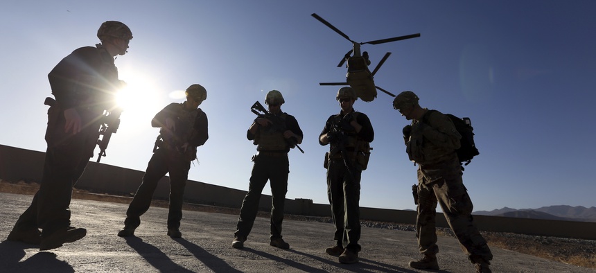 In this Nov. 30, 2017 file photo, American soldiers wait on the tarmac in Logar province, Afghanistan. The U.S. is pausing movement of troops into Afghanistan and quarantining 1,500 new arrivals to country due to virus.