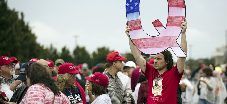 David Reinert holding a Q sign waits in line with others to enter a campaign rally with President Donald Trump and U.S. Senate candidate Rep. Lou Barletta, R-Pa., Aug. 2, 2018, in Wilkes-Barre, Pa.