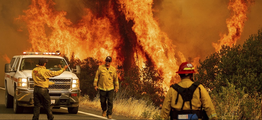 Flames from the LNU Lightning Complex fires leap above Butts Canyon Road on Sunday, Aug. 23, 2020, as firefighters work to contain the blaze in unincorporated Lake County, Calif.