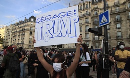 A protester holds a poster reading "Trump go away" during a demonstration Tuesday, June 2, 2020 in Paris.