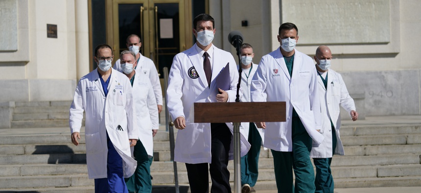 Dr. Sean Conley, physician to President Donald Trump, center, and other doctors, walk out to talk with reporters at Walter Reed National Military Medical Center, Monday, Oct. 5, 2020, in Bethesda, Md.