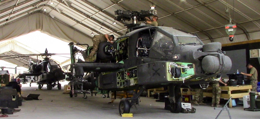 Soldiers work on an AH-64E Apache at Camp Taji Military Complex, Iraq, in July 2017.