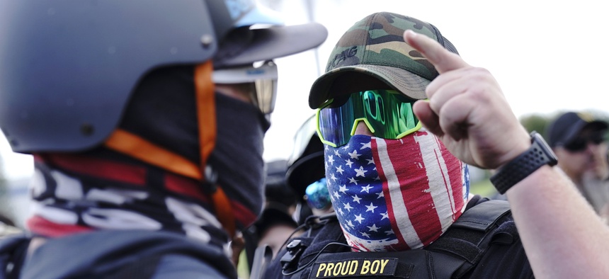In this Sept. 26, 2020 file photo, a right-wing demonstrator gestures toward a counter protester as members of the Proud Boys and other right-wing demonstrators rally in Portland, Ore.