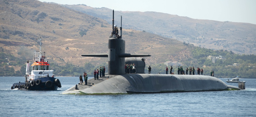A tug boat assists the Ohio-class cruise missile submarine USS Florida (SSGN 728) as it arrives in Souda Bay, Greece, for a scheduled port visit, Sept. 7, 2019.