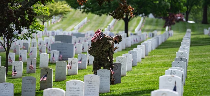 Soldiers assigned to the 3rd U.S. Infantry Regiment, known as “The Old Guard,” place American flags at headstones in Arlington National Cemetery, Arlington, Va., May 21, 2020.