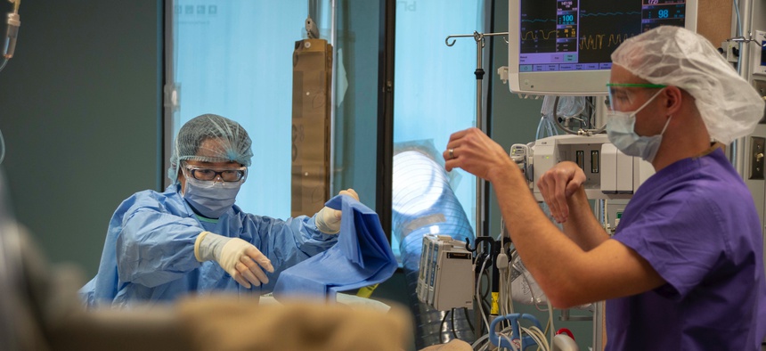 Lt. Youngmi Kim and Lt. Paul Cusmano prepare a patient for a procedure in Naval Medical Center San Diego's ICU on Nov. 2, 2020.