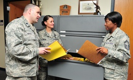 Lt. Col. Gregory Goforth discusses accounting files with members of the the 145 Comptroller Flight.