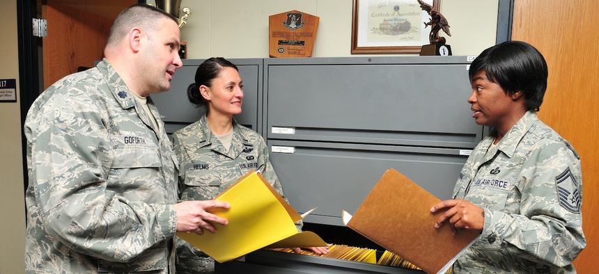 Lt. Col. Gregory Goforth discusses accounting files with members of the the 145 Comptroller Flight.