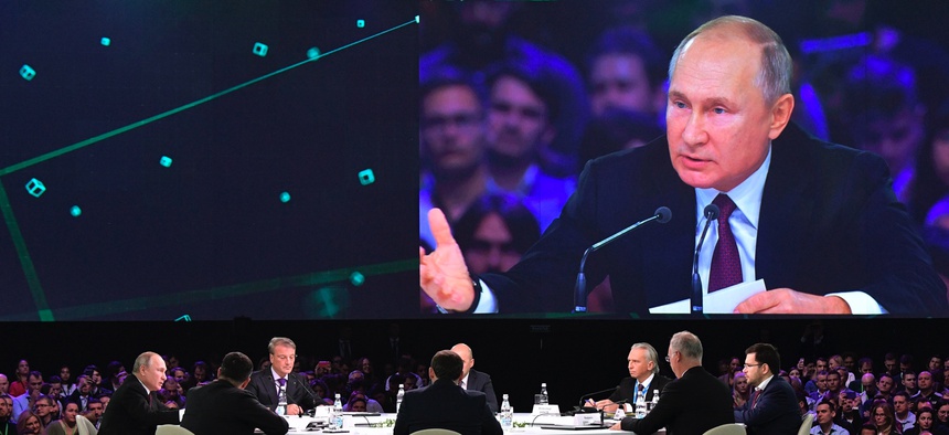 Russian President Vladimir Putin, left, attends a panel discussion at the Artificial Intelligence Journey forum in Moscow on Nov. 9, 2019.