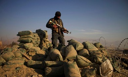An Afghan security force member stands at the site of a car bomb explosion in Khogiani district of the eastern Nangarhar province, Afghanistan, Feb. 7, 2021.