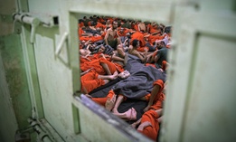 Men, suspected of being affiliated with the Islamic State (IS) group, gather in a prison cell in the northeastern Syrian city of Hasakeh on October 26, 2019. 