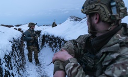 Ukrainian servicemen walk along a snow-covered trench guarding their position at the frontline near Vodiane, about 750 kilometers (468 miles) south-east of Kyiv, eastern Ukraine, Saturday, March 5, 2021.